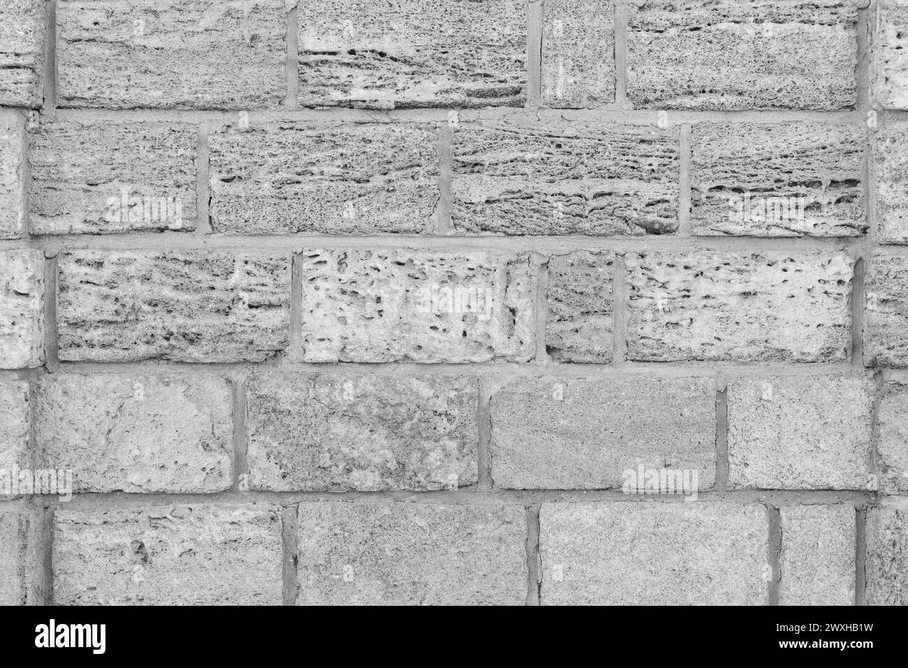 Graue Ziegelblöcke von Sandschale Kalkstein weiße natürliche Textur Wand Hintergrund. Stockfoto