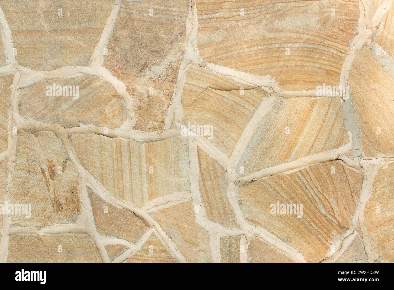 Hellgelbe Steinfliese Abstraktes Muster Felsoberfläche Grunge Textur Hintergrund Straßenstruktur. Stockfoto