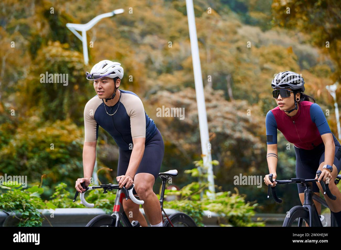 Junge asiatische Radfahrer, die auf der Landstraße Fahrrad fahren Stockfoto