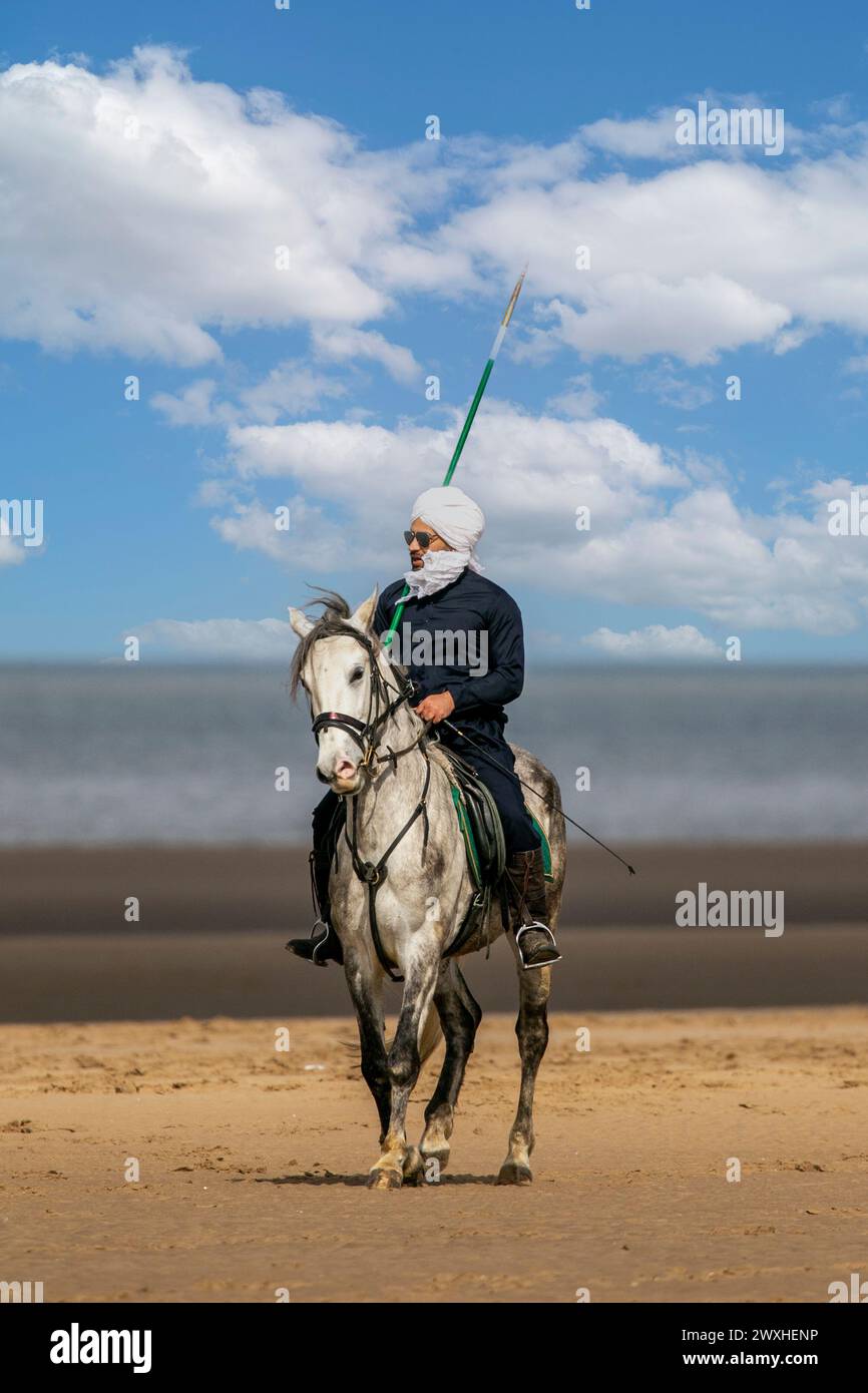 Altes Kavallerie-Spiel „Zelt-Pegging“ Reiter in Southport, Merseyside, 31.03.2024. Eine Gruppe von Männern spielt ihren Lieblingssport am Strand von Southport in der wunderschönen Ostersonne. Das Spiel, in Pakistan auch als Neza Bazi bekannt, ist eine Reitersportart uralten Ursprungs und ist eine von nur zehn von der International Equestrian Federation offiziell anerkannten Reitdisziplinen. Quelle: Cernan Elias/Alamy Live News Stockfoto