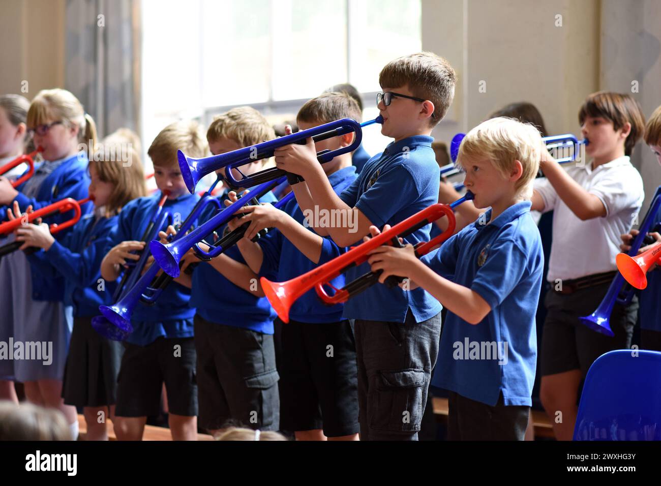 Schulmusikschüler spielten Plastiktrompeten an der Grundschule, Großbritannien, 2018 Stockfoto