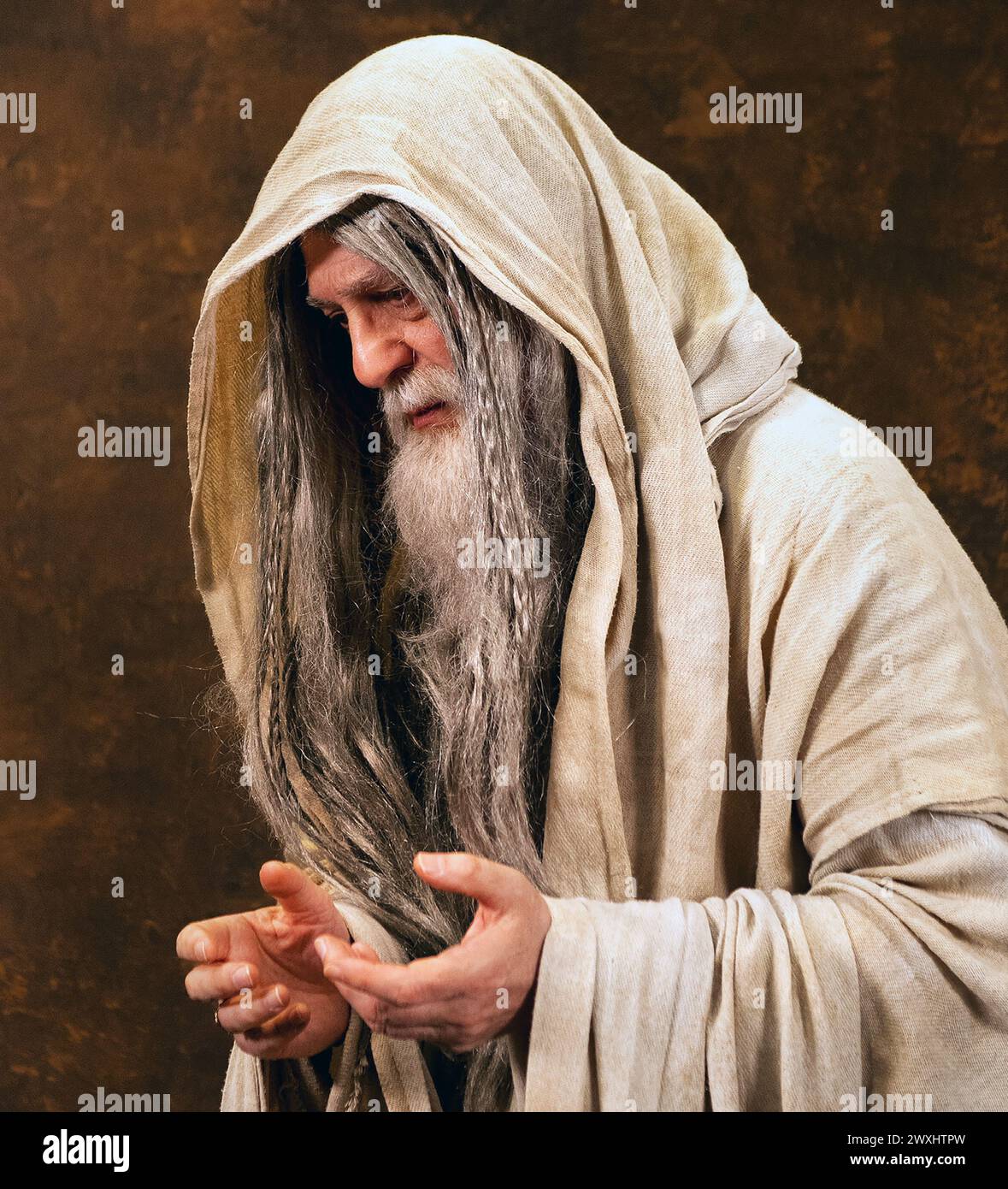Porträt eines alten Mannes mit einem Bart und langen Haaren, gekleidet in einem hellbraunen kapuzenumhang. Mark Dunn / Mark Dunn Fotografie Stockfoto