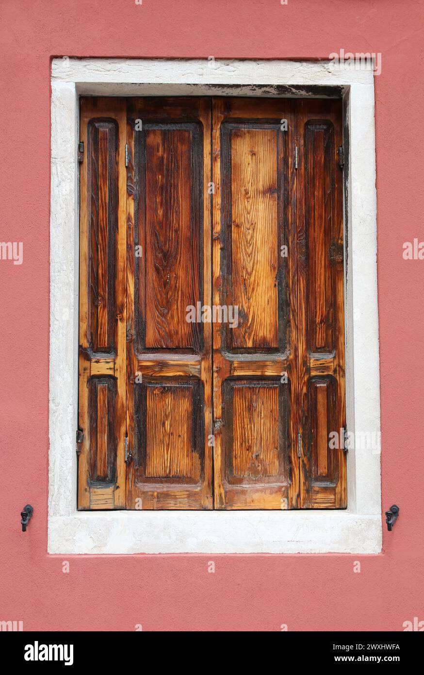 Altes Holzfenster mit Fensterläden und roter Vintage-Wand in Venedig Italien Stockfoto