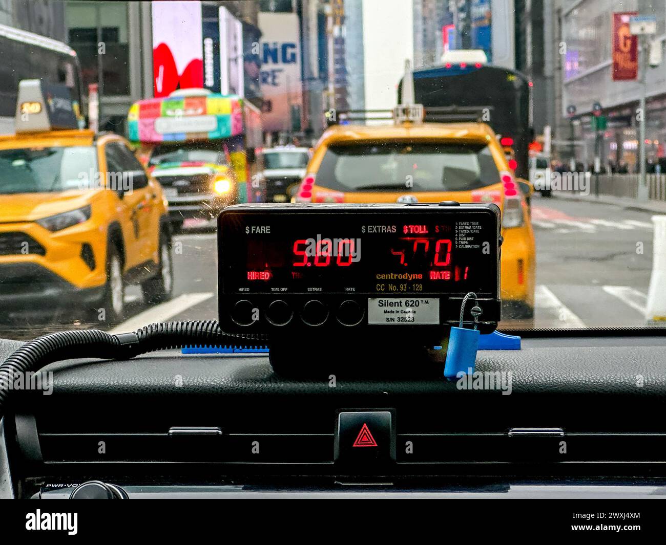NEW YORK, NY, USA - 27. MÄRZ 2024: Der Blick vom Rücksitz eines Taxis zeigt eine lebhafte Stadtszene mit gelbem Taxi und Fahrpreismesser Stockfoto