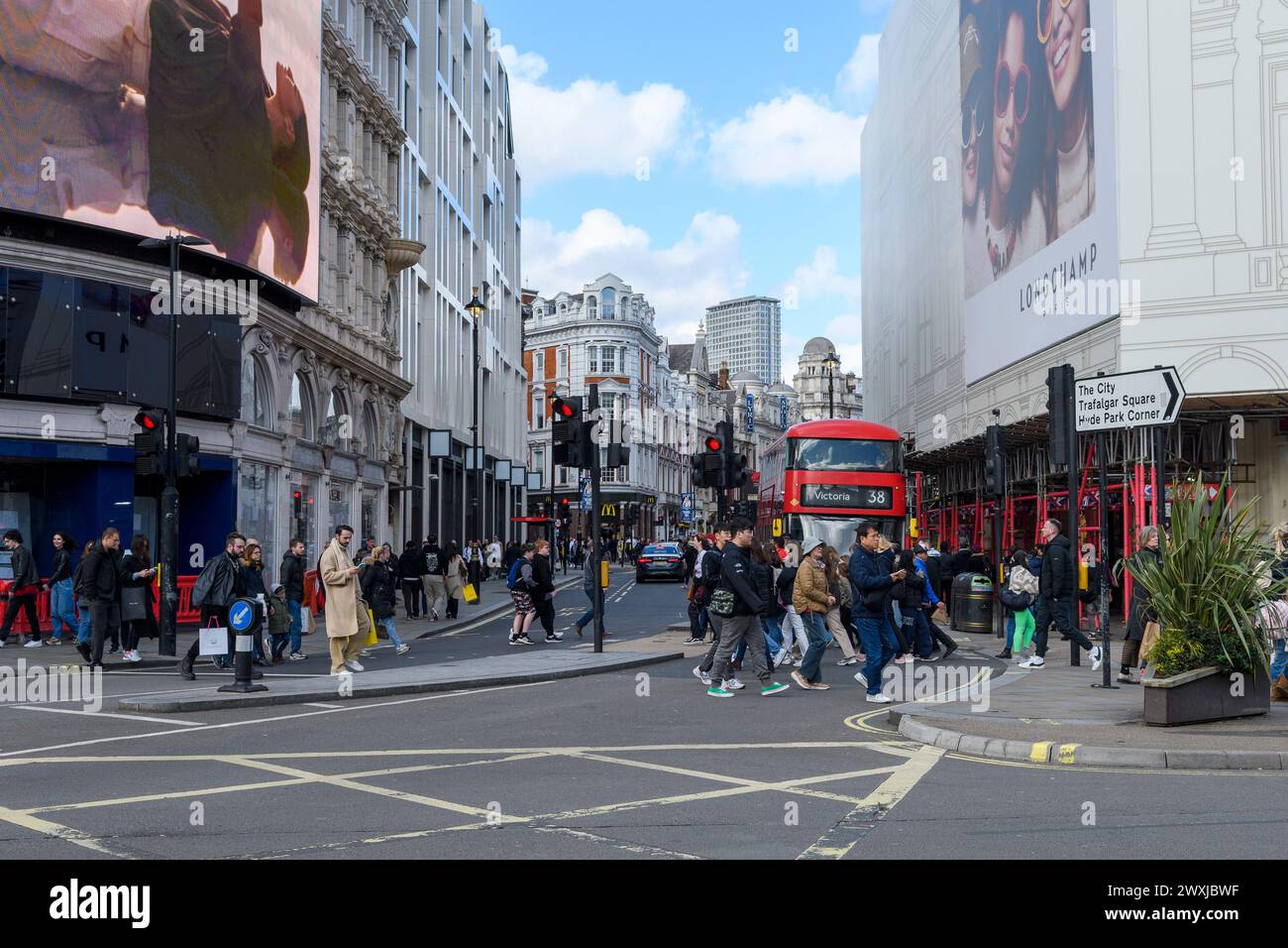 Shaftesbury Avenue Piccadilly Circus Kreuzung mit Menschen, die die Straße überqueren, und rotem Londoner Bus Stockfoto