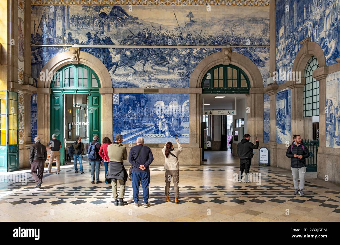 Besucher bewundern das Azulejo-Fliesengemälde am Bahnhof Sao Bento in Porto, Portugal Stockfoto