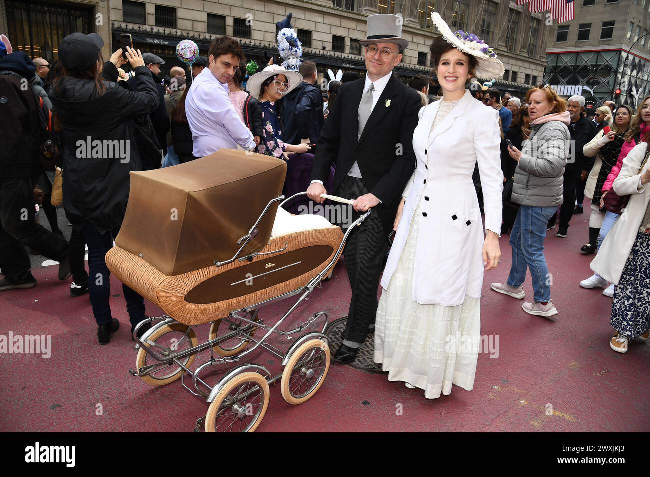 New York, USA. 31. März 2024. Matthew Karl Gale und Michelle Coursey kleiden sich in historischen Kostümen und schieben ihr Kind in einem Kinderwagen durch Menschenmassen, die sich bei der Osterparade vor der Saint Patrick's Cathedral an der 5th Avenue, New York, NY, am 31. März 2024 versammelten. (Foto: Anthony Behar/SIPA USA) Credit: SIPA USA/Alamy Live News Stockfoto