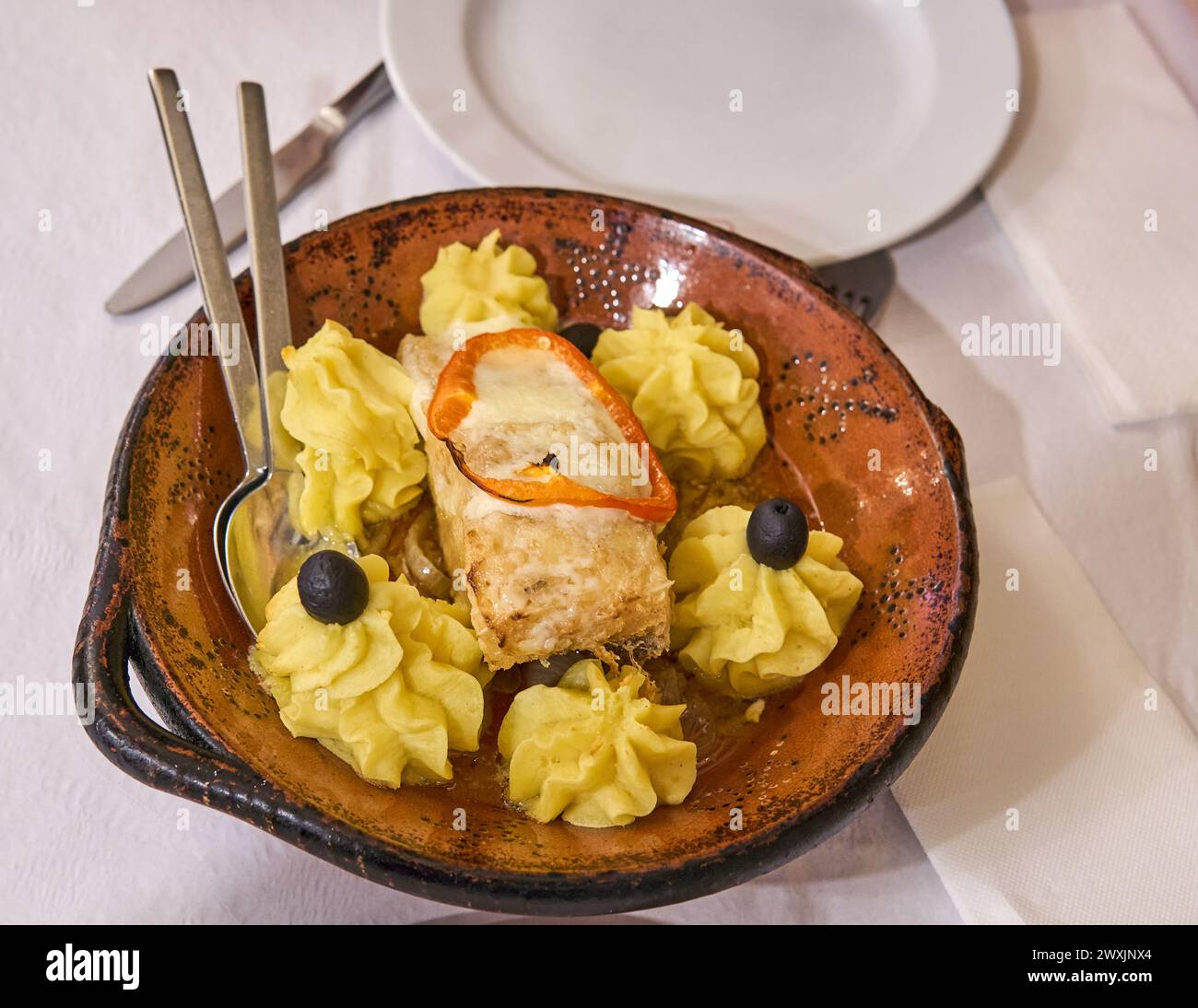 Gourmet-Fischgericht mit Kartoffelpüree und Oliven. Konzept der Gourmet-Mahlzeit Stockfoto