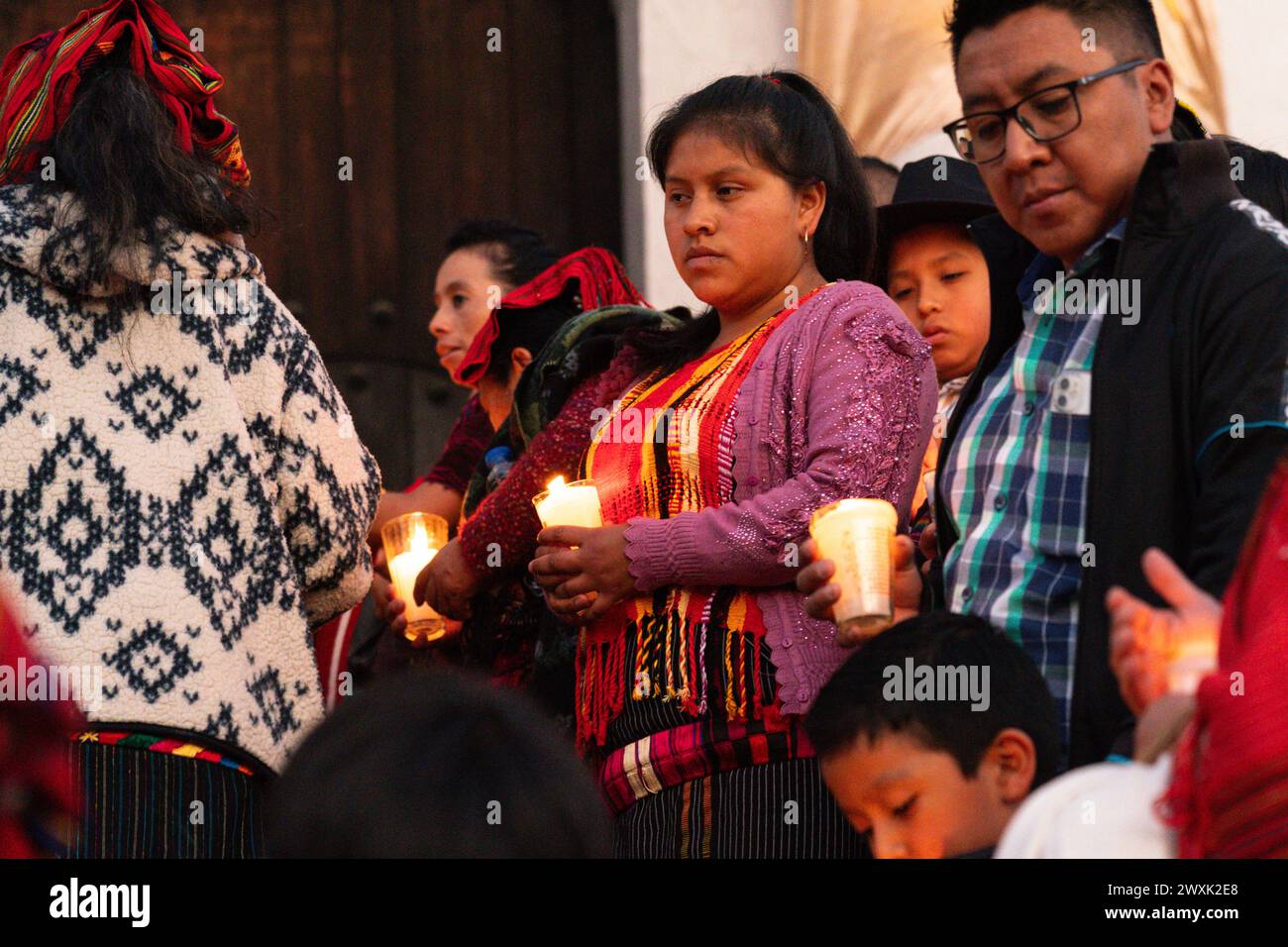 Chichicastenango, Guatemala. 30. März 2024. Indigene Maya-Frauen, die traditionelle Huipiles tragen, halten Kerzen auf den Stufen der Kirche Iglesia de Santo Tomás vor einer Mahnwache zum Heiligen Samstag, dem 30. März 2024 in Chichicastenango, Guatemala. Die katholische Kirche und die Maya-Glaubenssätze haben sich vor langer Zeit in den indigenen Regionen Guatemalas in einem Prozess gemischt, der Synkretismus genannt wird. Quelle: Richard Ellis/Richard Ellis/Alamy Live News Stockfoto