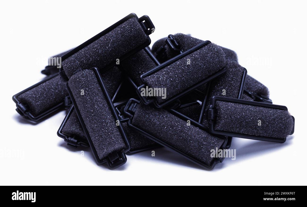 Haufen Lockenwickler auf weiß ausgeschnitten. Stockfoto