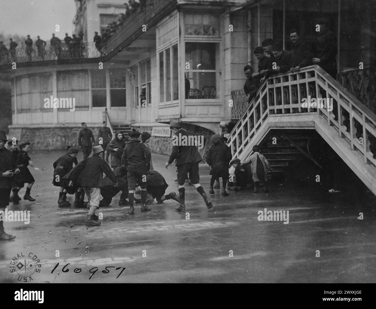 A.E.F. MÄNNER GENIESSEN das wilde Ringen, das die französischen Kinder machen, um Münzen zu jagen, die die Soldaten ihnen zuwerfen. Bereich Verlassen. St. Malo, Ille et Vilaine, Frankreich CA. 1919 Stockfoto