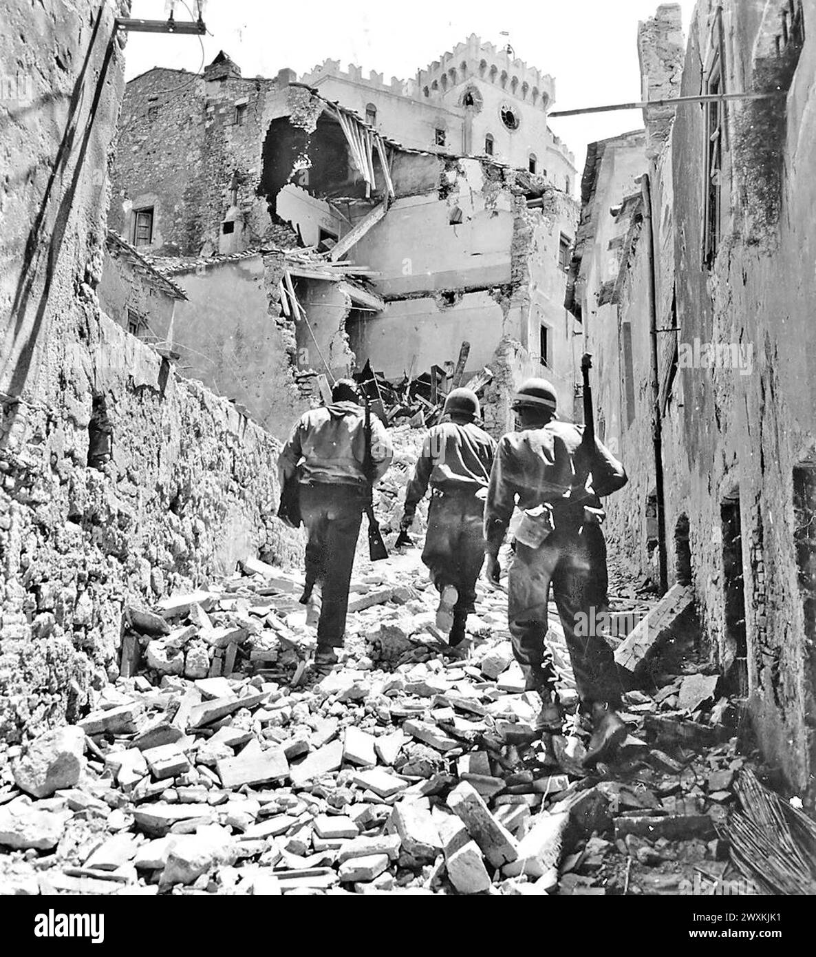 Originalüberschrift: 'Fünfte Armee, Rosignano Gebiet, Italien. Zwei amerikanische Infanteristen der 34. Infanterie-Division laufen mit einer italienischen Partisanen durch die Stadt Rosignano. 1944 Stockfoto
