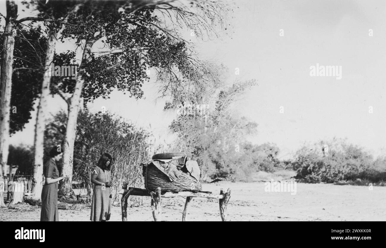 Foto der Feldschwester, Mabel Cowser und eines jungen Mädchens auf einer unbekannten kalifornischen Indianerrettung mit einem Aufbewahrungskorb mit Food Supplies CA. 1936-1942 Stockfoto