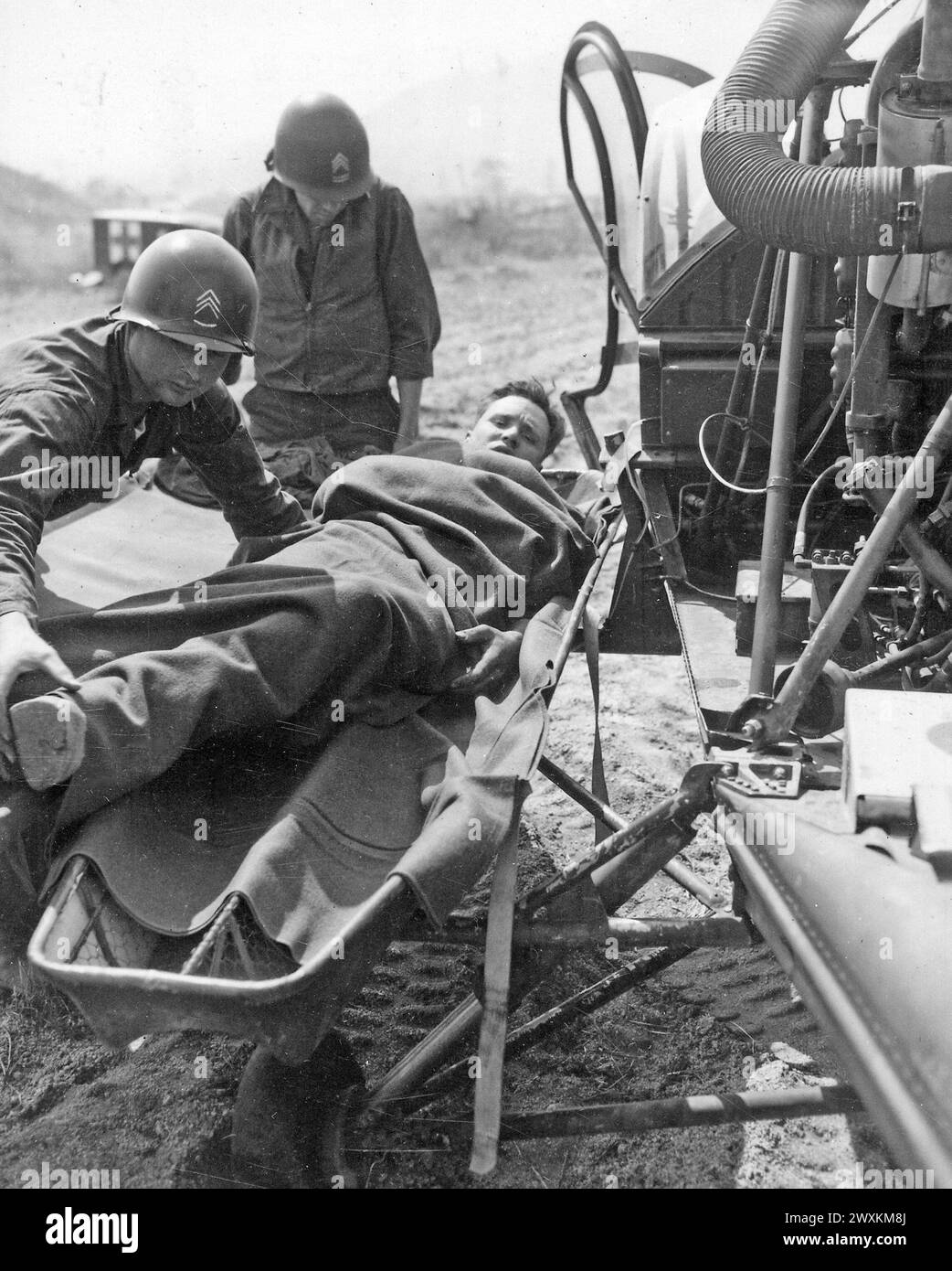 Ein verwundeter Amerikaner wird auf einen Hubschrauber in der Sammelstation des 21. Infanterieregiments in Painmal, Korea, eine Meile südlich des 38. Breitengrades, gebracht, um in ein Basiskrankenhaus ca. 1951 Stockfoto