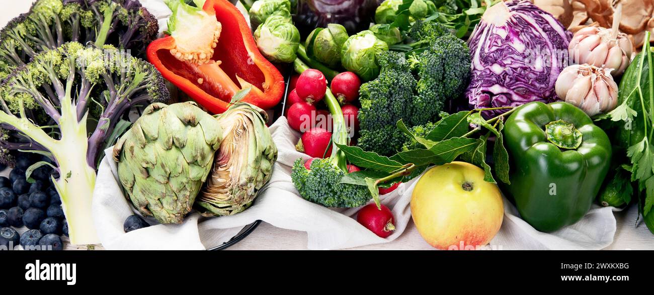 Tisch mit Gemüse auf hellem Holzhintergrund. Pfeffer, Kohl, Brokkoli, Rettich, Knoblauch. Konzept für gesunde Ernährung. Banner Stockfoto