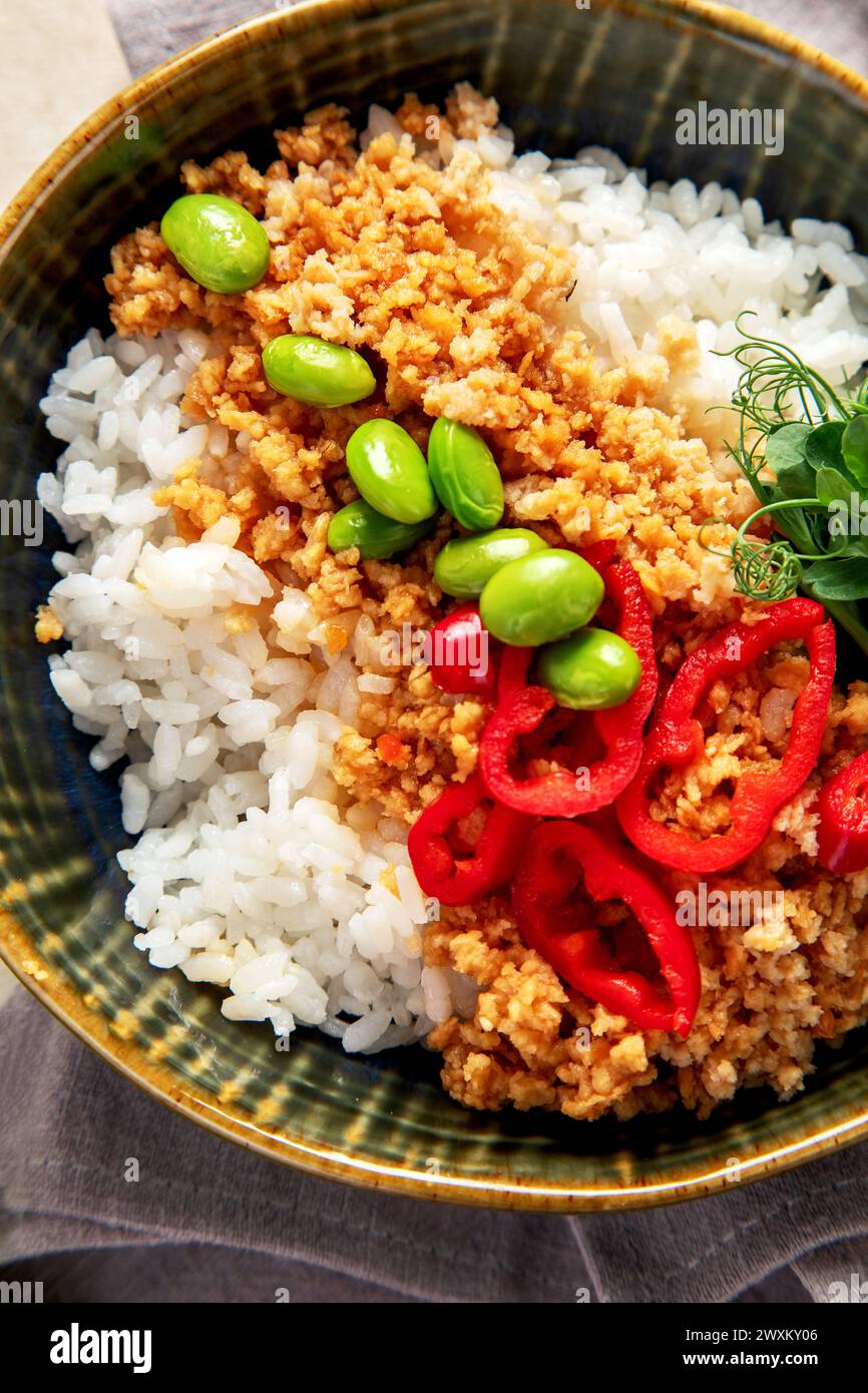 Veganes Essen. Sojafleisch, weißer Reis, Bohnen, roter Pfeffer auf hellem hölzernem Hintergrund. Draufsicht Stockfoto