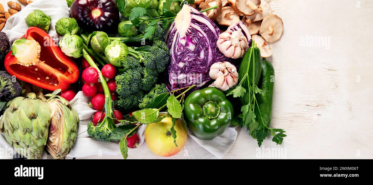 Tisch mit Gemüse auf hellem Holzhintergrund. Pfeffer, Kohl, Brokkoli, Rettich, Knoblauch. Konzept für gesunde Ernährung. Draufsicht, Kopierbereich, Banner Stockfoto