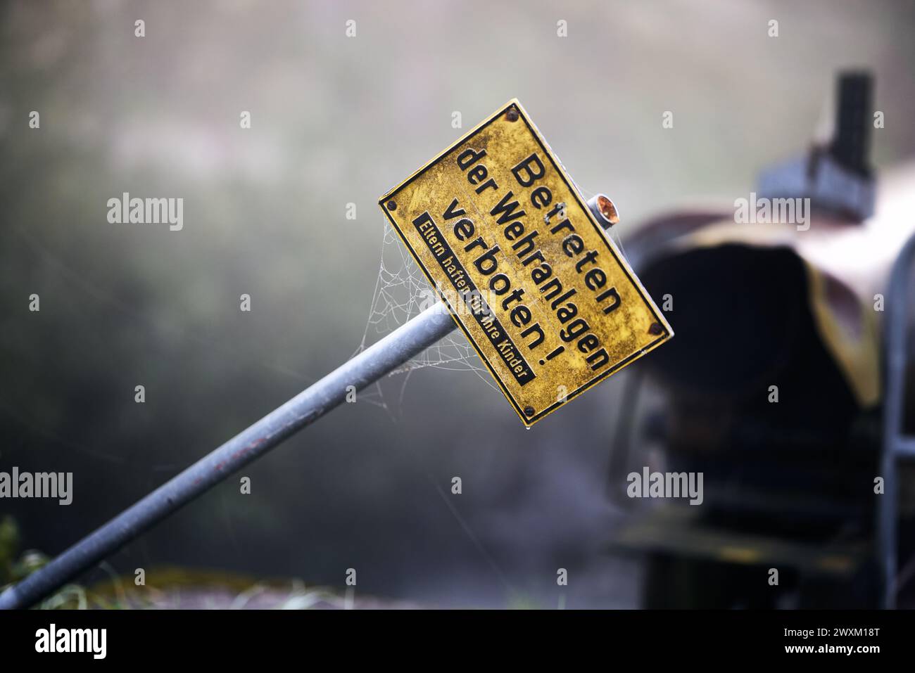 Nahaufnahme eines Schildes an einem Pfosten neben einem Auto Stockfoto