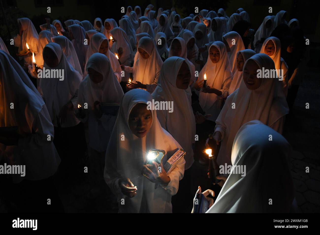 31. März 2024, Boyolali, Zentral-Java, Indonesien: Schüler beten und rezitieren den Koran mit Sentir-Lampen (Laternen) auf dem Feld, das die Ankunft der Nacht von Lailatul Qadar während des Fastenmonats Ramadan in der Nurul Hidayat-Schule in Andong, Boyolali, Zentral-Java, am Sonntagabend markiert. 31. März 2024. Der heilige Monat Ramadan ist der islamische Kalender und es wird angenommen, dass die Offenbarung der ersten Verse im Koran in den letzten 10 Nächten gefallen ist. Der Monat Ramadan ist auch eine Zeit für gesellige Kontakte, vor allem am Abend, nachdem das Fastenbrechen unterbrochen und alle Aktivitäten auf t verschoben wurden Stockfoto