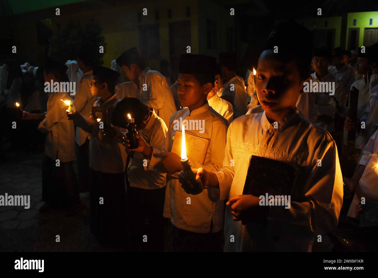 31. März 2024, Boyolali, Zentral-Java, Indonesien: Schüler beten und rezitieren den Koran mit Sentir-Lampen (Laternen) auf dem Feld, das die Ankunft der Nacht von Lailatul Qadar während des Fastenmonats Ramadan in der Nurul Hidayat-Schule in Andong, Boyolali, Zentral-Java, am Sonntagabend markiert. 31. März 2024. Der heilige Monat Ramadan ist der islamische Kalender und es wird angenommen, dass die Offenbarung der ersten Verse im Koran in den letzten 10 Nächten gefallen ist. Der Monat Ramadan ist auch eine Zeit für gesellige Kontakte, vor allem am Abend, nachdem das Fastenbrechen unterbrochen und alle Aktivitäten auf t verschoben wurden Stockfoto