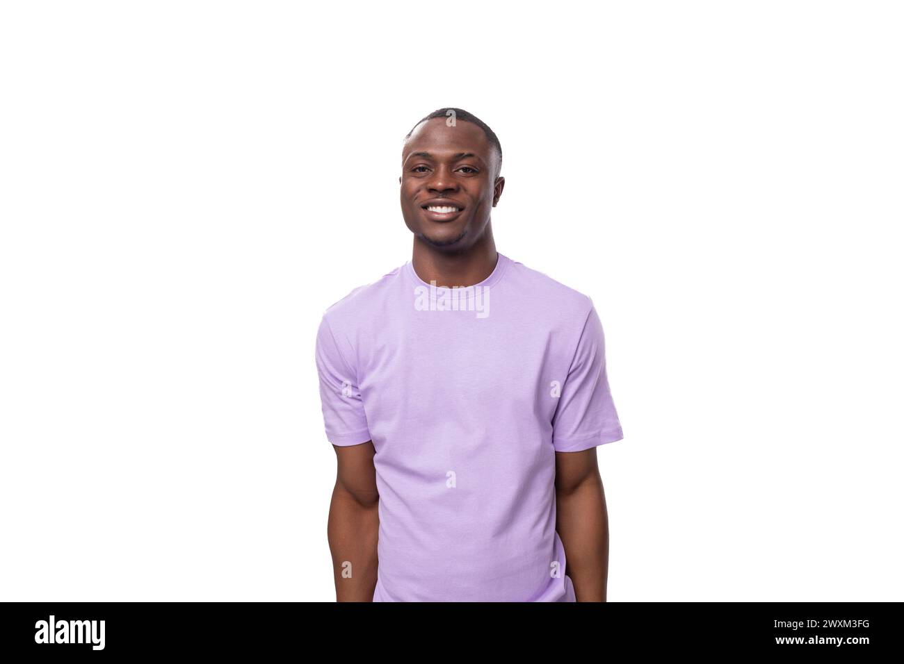 Porträt eines jungen lächelnden amerikanischen Mannes in Flieder-T-Shirt isoliert auf weißem Hintergrund mit Kopierraum Stockfoto