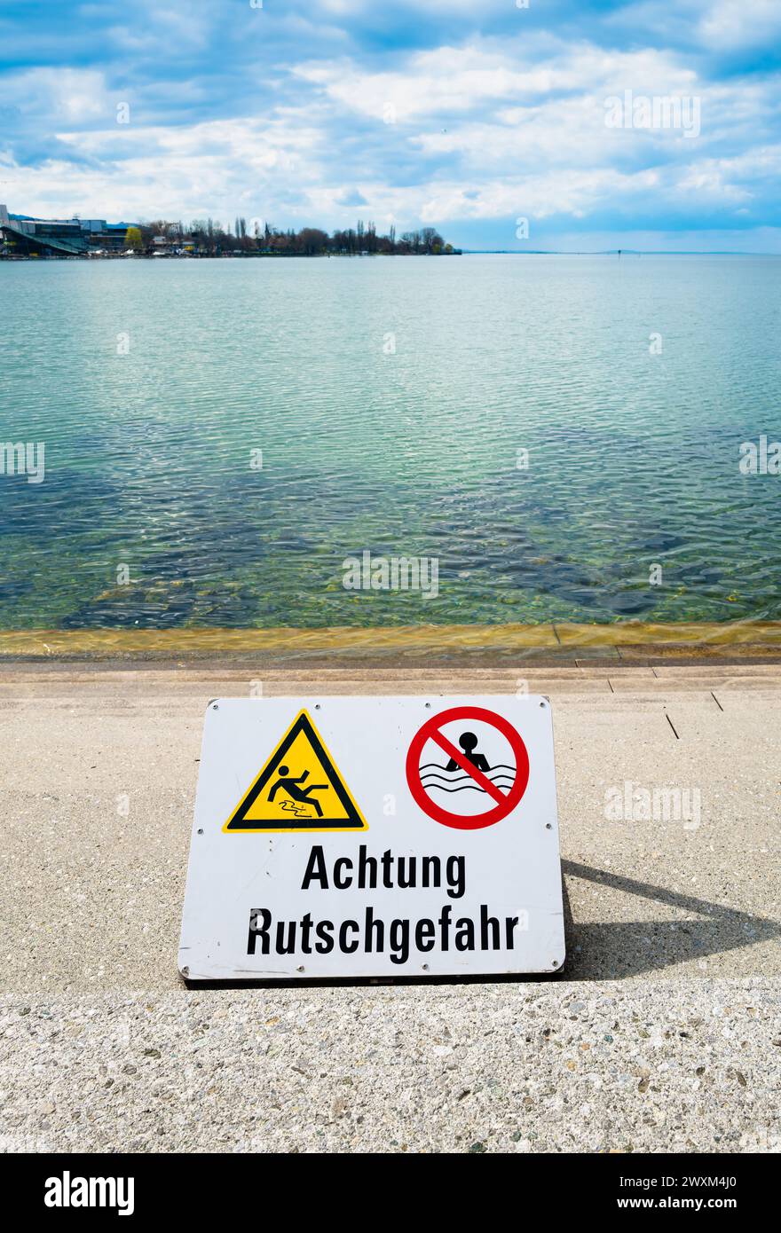 Deutsches Schild am Bodensee in Bregenz, Österreich. Warnung: Rutschgefahr Stockfoto