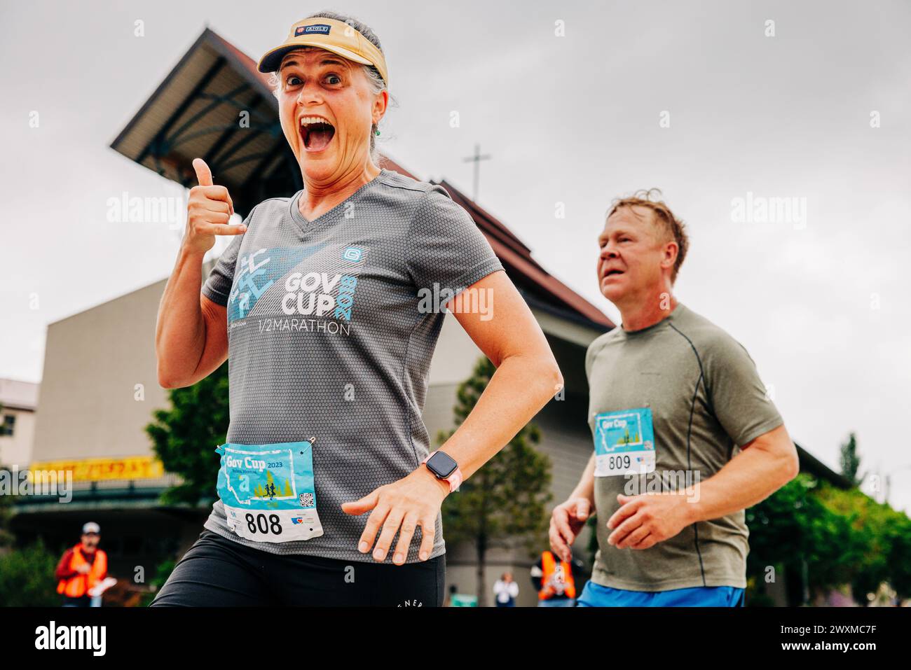 Glückliche und aufgeregte Frau, die den Governor's Cup Marathon läuft Stockfoto