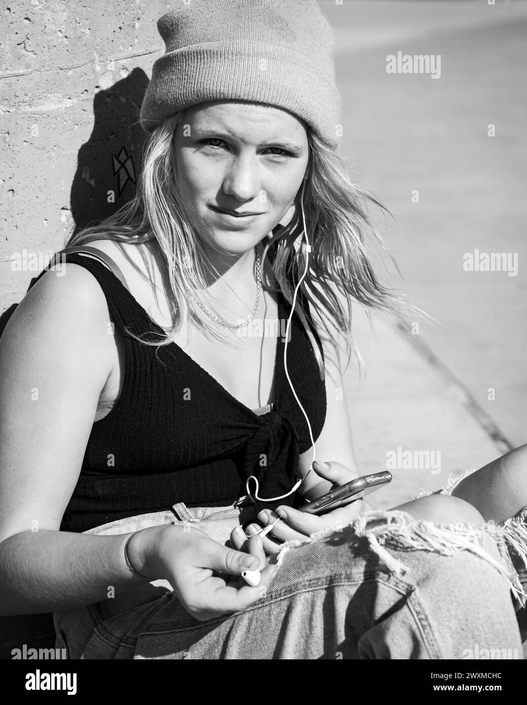 Skater Girl trägt Mütze und Kopfhörer Stockfoto