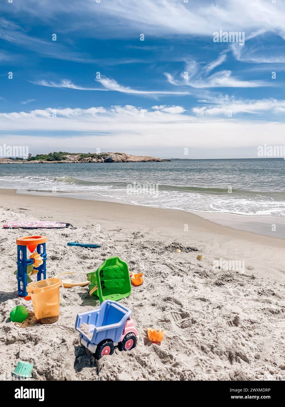 Hat Strandspielzeug an einem sonnigen Tag an einem leeren Strand liegen gelassen. Stockfoto