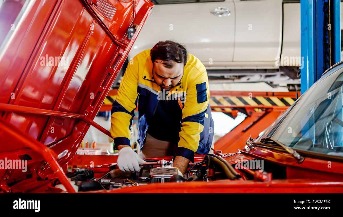 Ein männlicher Arbeiter repariert ein Auto in einer Garage Stockfoto