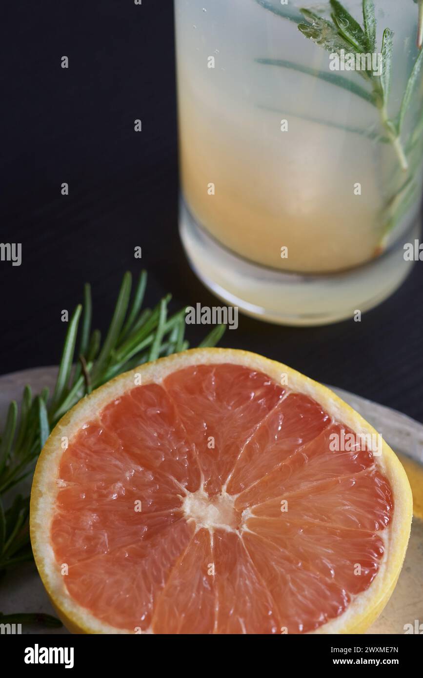 Grapefruit schneiden und neben Cocktail garnieren Stockfoto