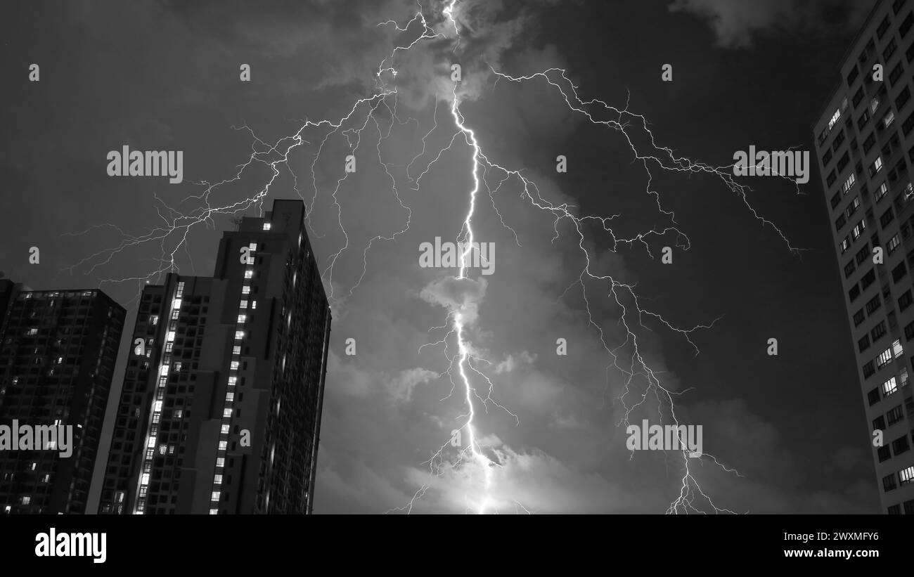 Unglaublicher echter Blitz über dem urbanen Nachthimmel in Schwarzweiß Stockfoto