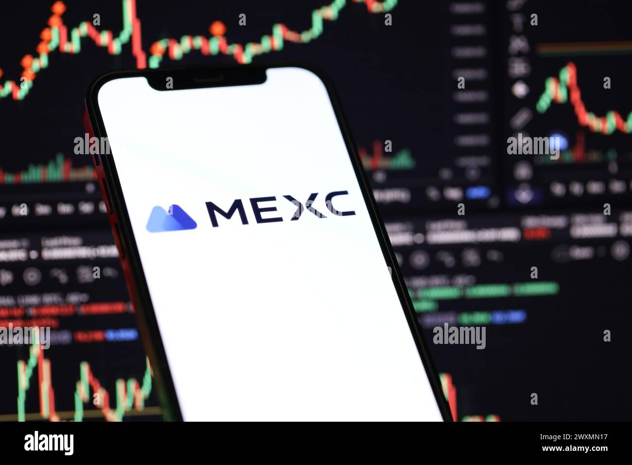 KIEW, UKRAINE - 15. MÄRZ 2024 MEXC-Logo auf dem iPhone-Display und Kryptowährungswertdiagrammen. Portal für den Austausch von Kryptowährungen Stockfoto