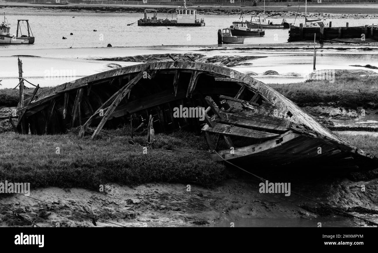 Die verfallenen Überreste eines hölzernen Fischerbootes tauchten im Schlamm im Fährhafen von Felixstowe in Suffolk England. Februar 2024 Stockfoto