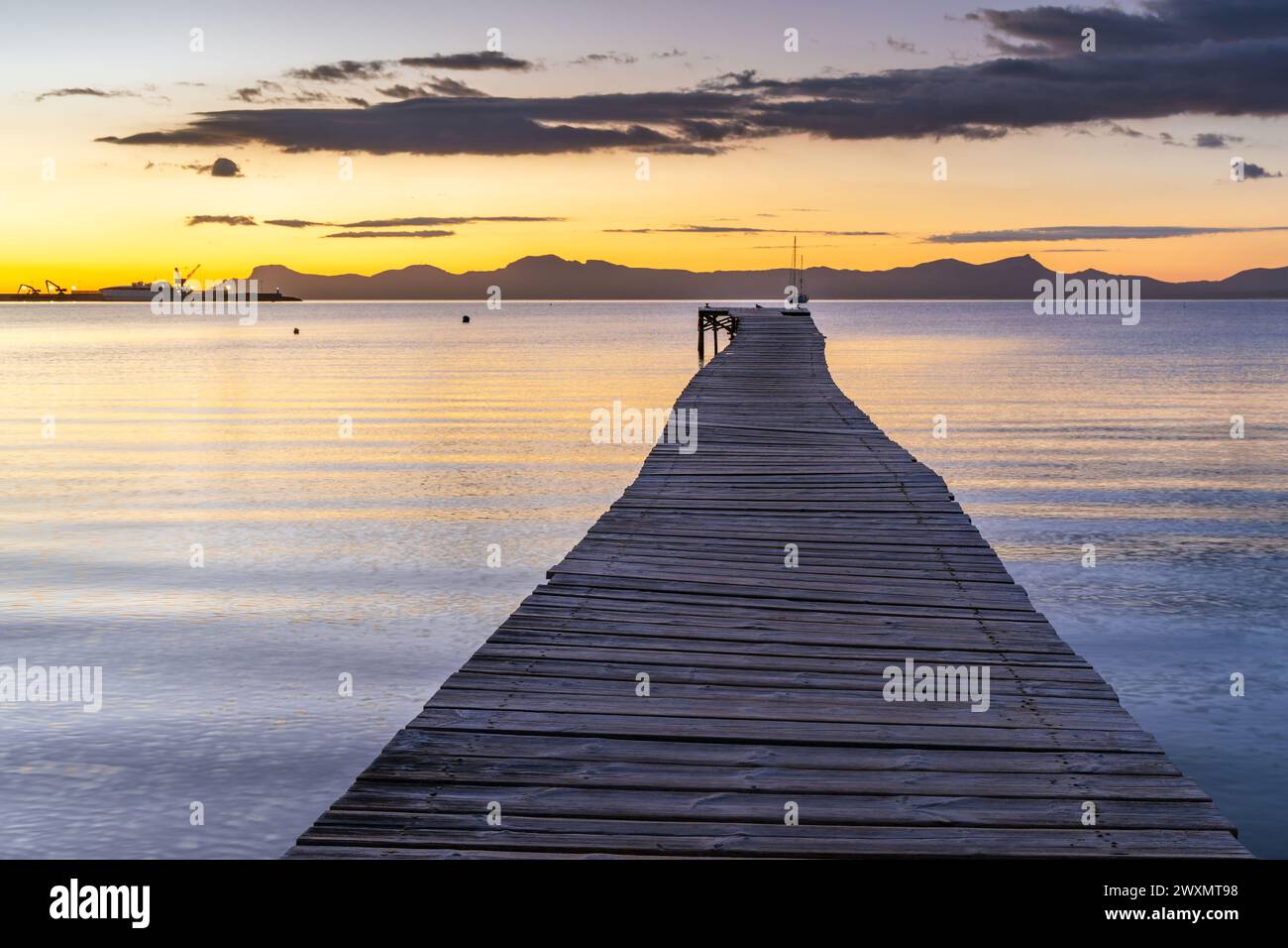 Holzsteg bei Sonnenaufgang in der Bucht von Port d'Alcudia auf Mallorca Stockfoto