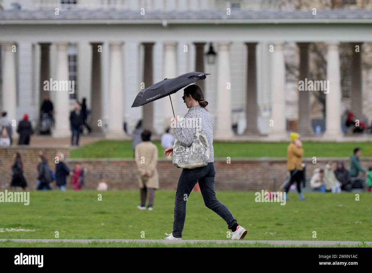 Eine Frau, die in Greenwich Park, London, während eines Regenschauer läuft, da Teile Großbritanniens von Regengüssen heimgesucht werden, wenn Reisende am Ende des Osterwochenendes nach Hause zurückkehren. Bilddatum: Montag, 1. April 2024. Stockfoto