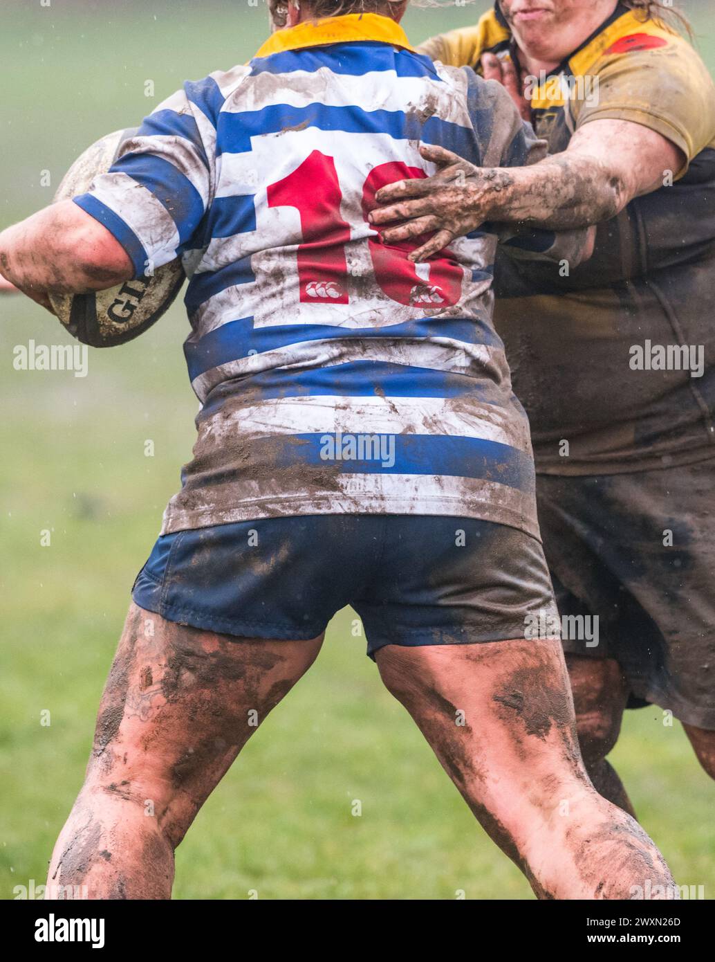 Englische Amateur-Rugby-union-Frauen spielen unter nassen und schlammigen Bedingungen und ein Nummer 18-Trikot. Stockfoto