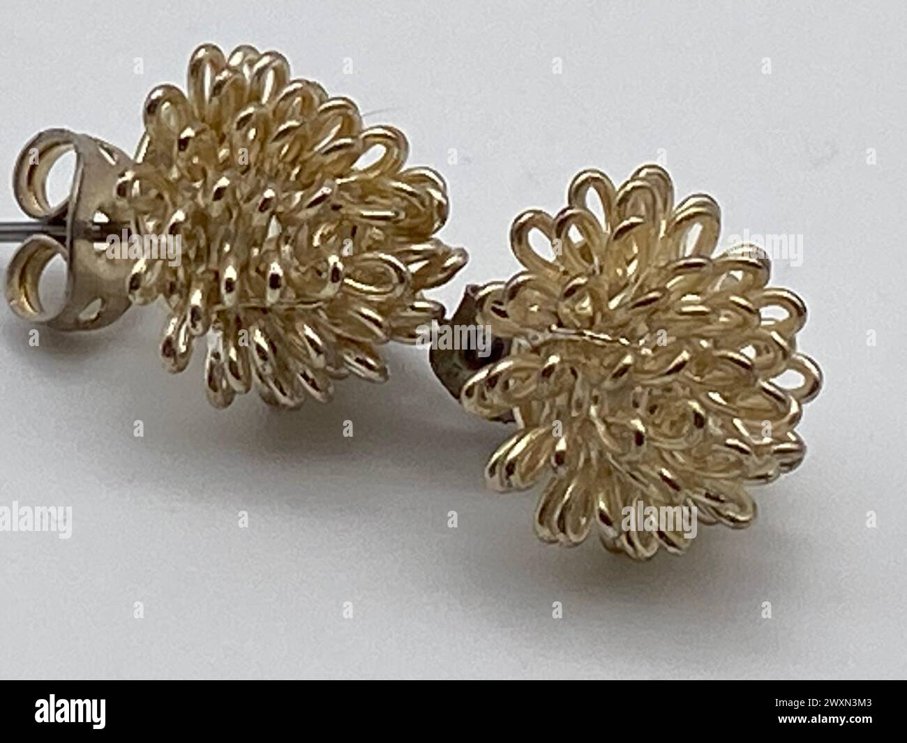 Zwei Ohrringe gegen einen weißen und grauen Hintergrund Stockfoto