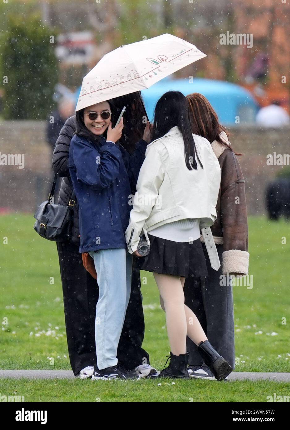 Die Menschen in Greenwich Park, London, werden während eines Regenschauer, als Teile Großbritanniens, von Regengüssen heimgesucht werden, wenn Reisende am Ende des Osterwochenendes nach Hause zurückkehren. Bilddatum: Montag, 1. April 2024. Stockfoto