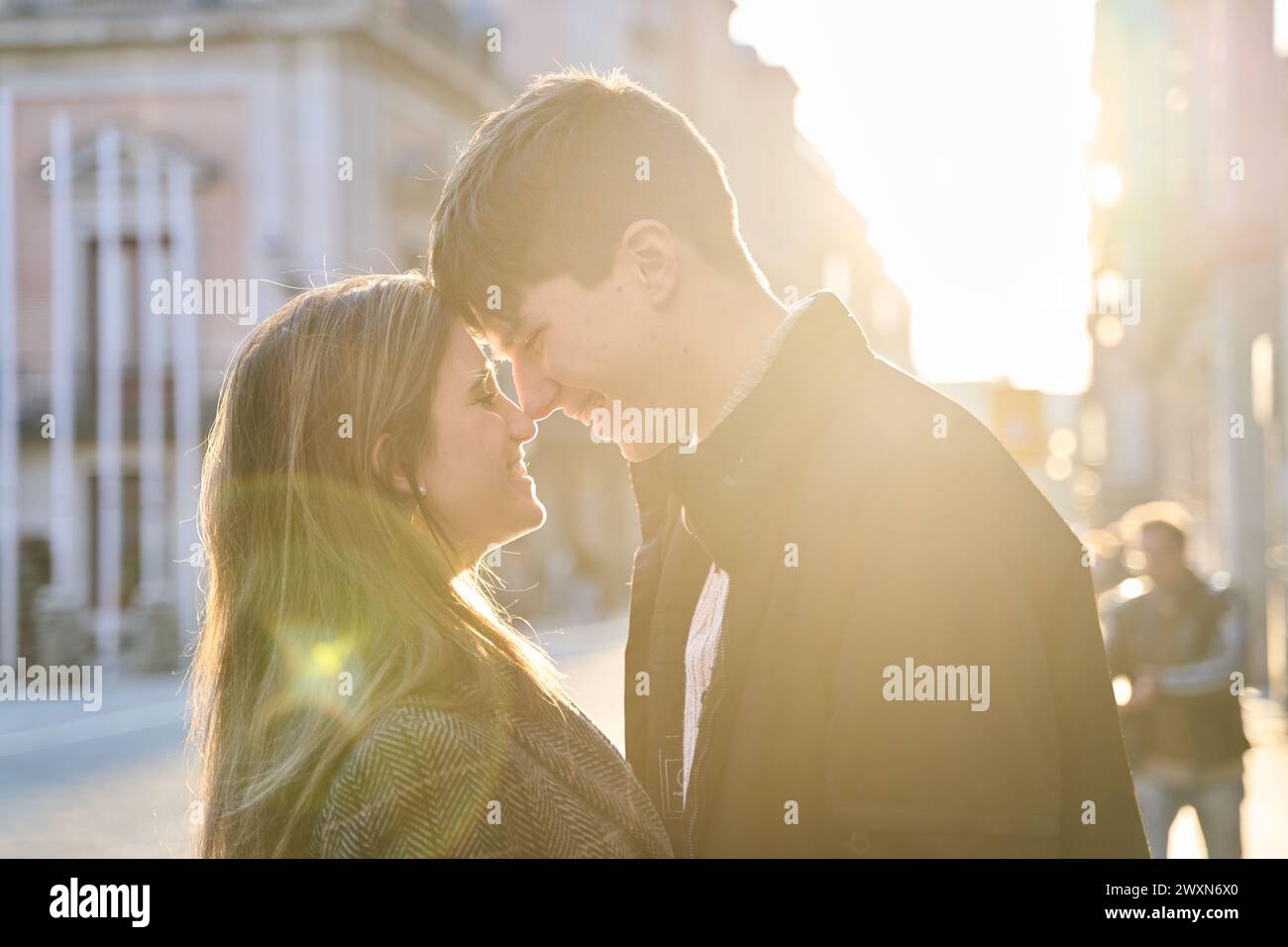 Nahaufnahme, Porträt einer schönen jungen kaukasischen Paar küssen gegen Sonnenuntergang Licht, während außerhalb zurückgehen. Stockfoto
