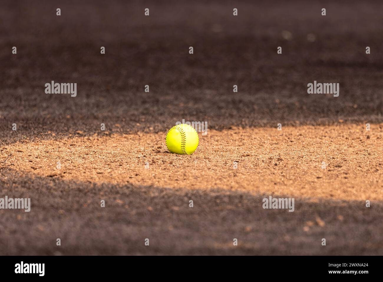 Optischer gelber Softball auf Tonkrügen mit braunem Kunstrasen Stockfoto