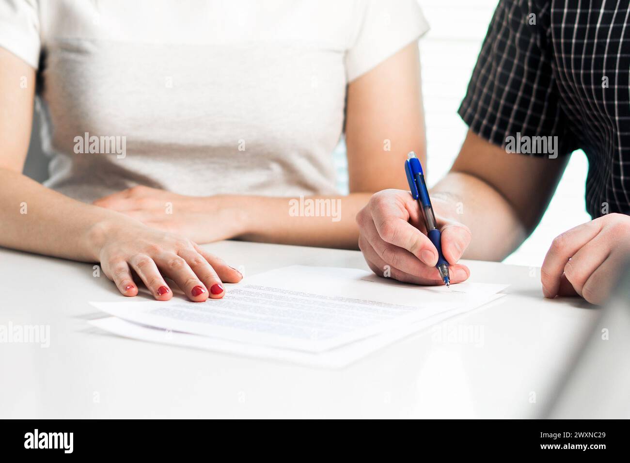 Scheidungsvereinbarung. Ein Paar unterzeichnet ein rechtliches Dokument. Ehevertrag, Ehevertrag. Anwaltsversammlung. Trennung, Trennung oder Klage. Stockfoto