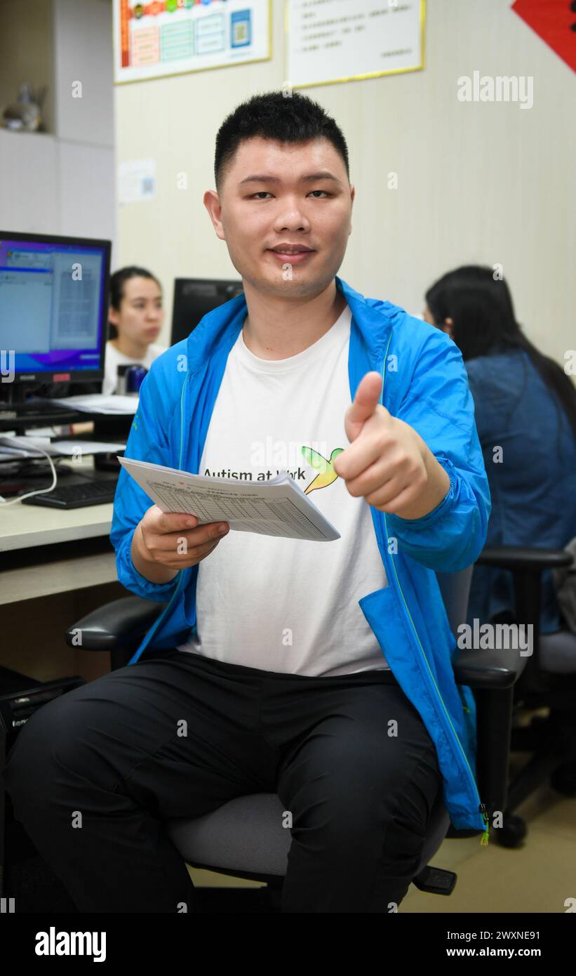 (240401) -- SHENZHEN, 1. April 2024 (Xinhua) -- Dai Jinyu, ein 29-jähriger autistischer Jugendlicher, posiert für ein Foto bei der Shenzhen Autism Society in Shenzhen, südchinesischer Provinz Guangdong, 27. März 2024. Dai Jinyu trat der Organisation im Oktober 2018 bei und war hauptsächlich für das Scannen und Kopieren von Dateien und die Desinfektion in Innenräumen verantwortlich. Dieser Dienstag ist der 17. Welttag des Autismus. Im südchinesischen Shenzhen haben sich einige autistische Jugendliche, die als "Kinder der Sterne" bezeichnet wurden, in die Gesellschaft integriert und verfolgen ihren Träumen nach. In den letzten Jahren haben autistische Kinder in China immer mehr an Bedeutung gewonnen Stockfoto