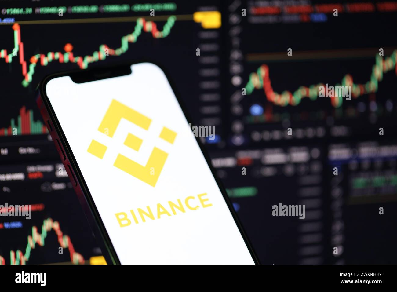 KIEW, UKRAINE - 15. MÄRZ 2024 Binance-Logo auf dem iPhone-Display und Kryptowährungswertdiagrammen. Portal für den Austausch von Kryptowährungen Stockfoto
