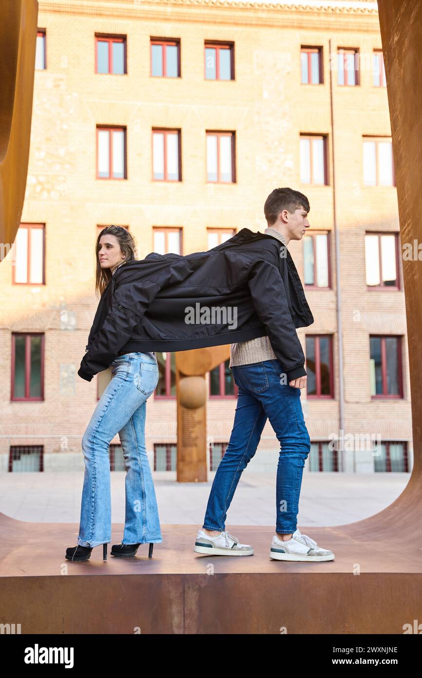 Vertikales Foto eines Paares, das sich einen Mantel teilt Stockfoto