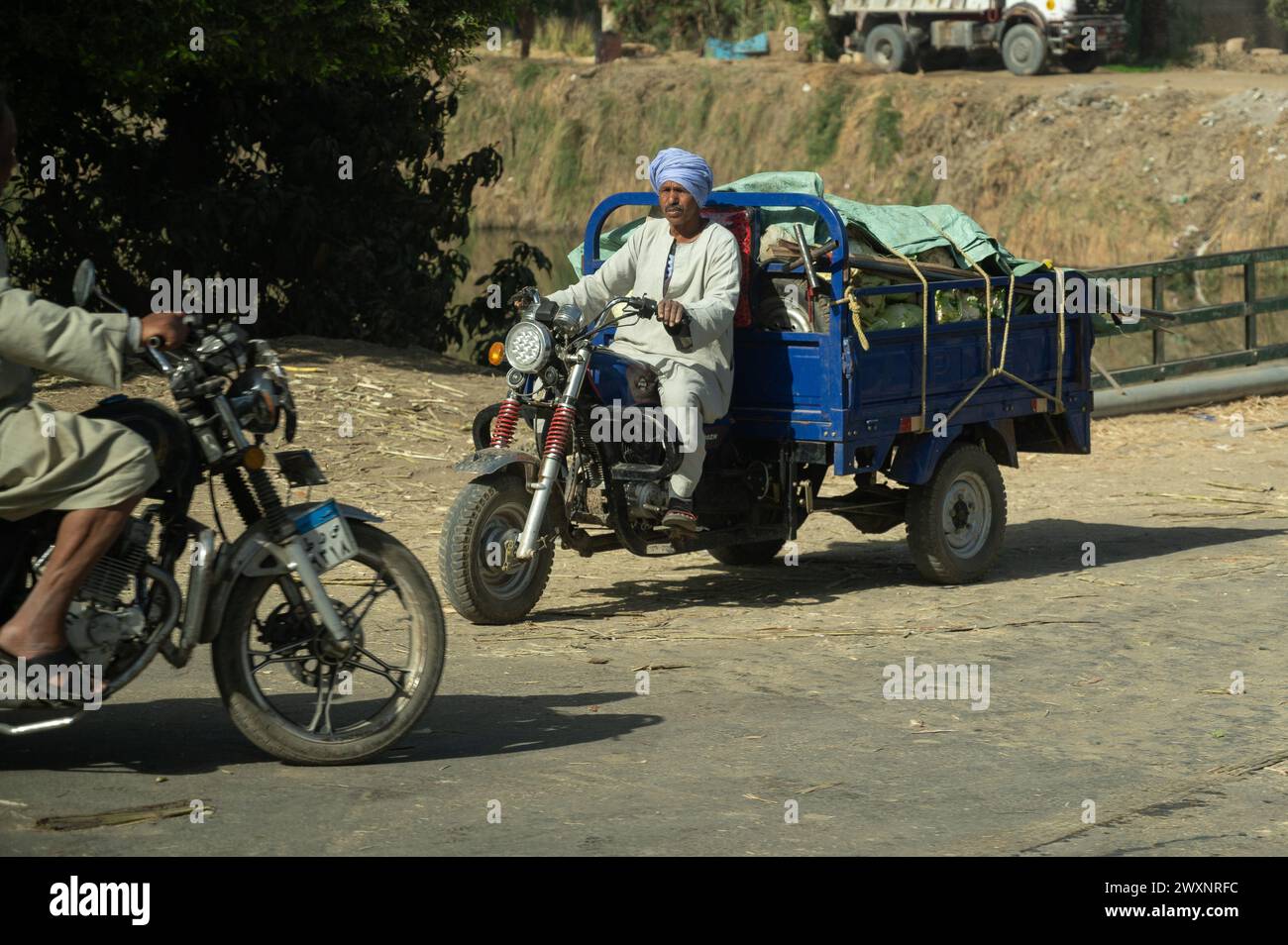 Arabischer Mann, der Motorrad mit Güterwagen fährt Stockfoto