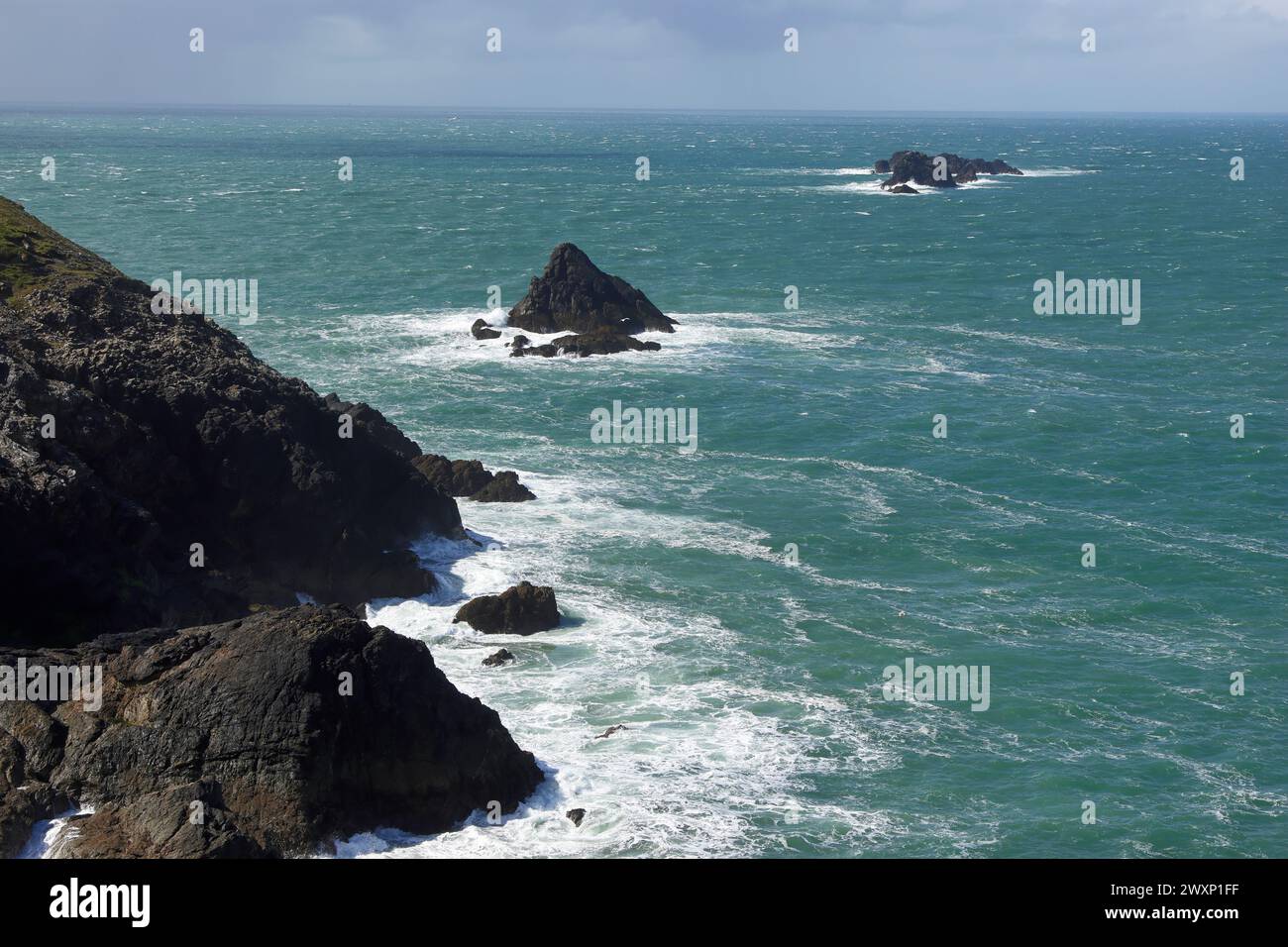 Blick in der Nähe von Trevose Head, Cornwall, mit wechselnden Lichtverhältnissen, verstreuten Wolken und sonnendurchflutetem Meer und Landschaft Stockfoto