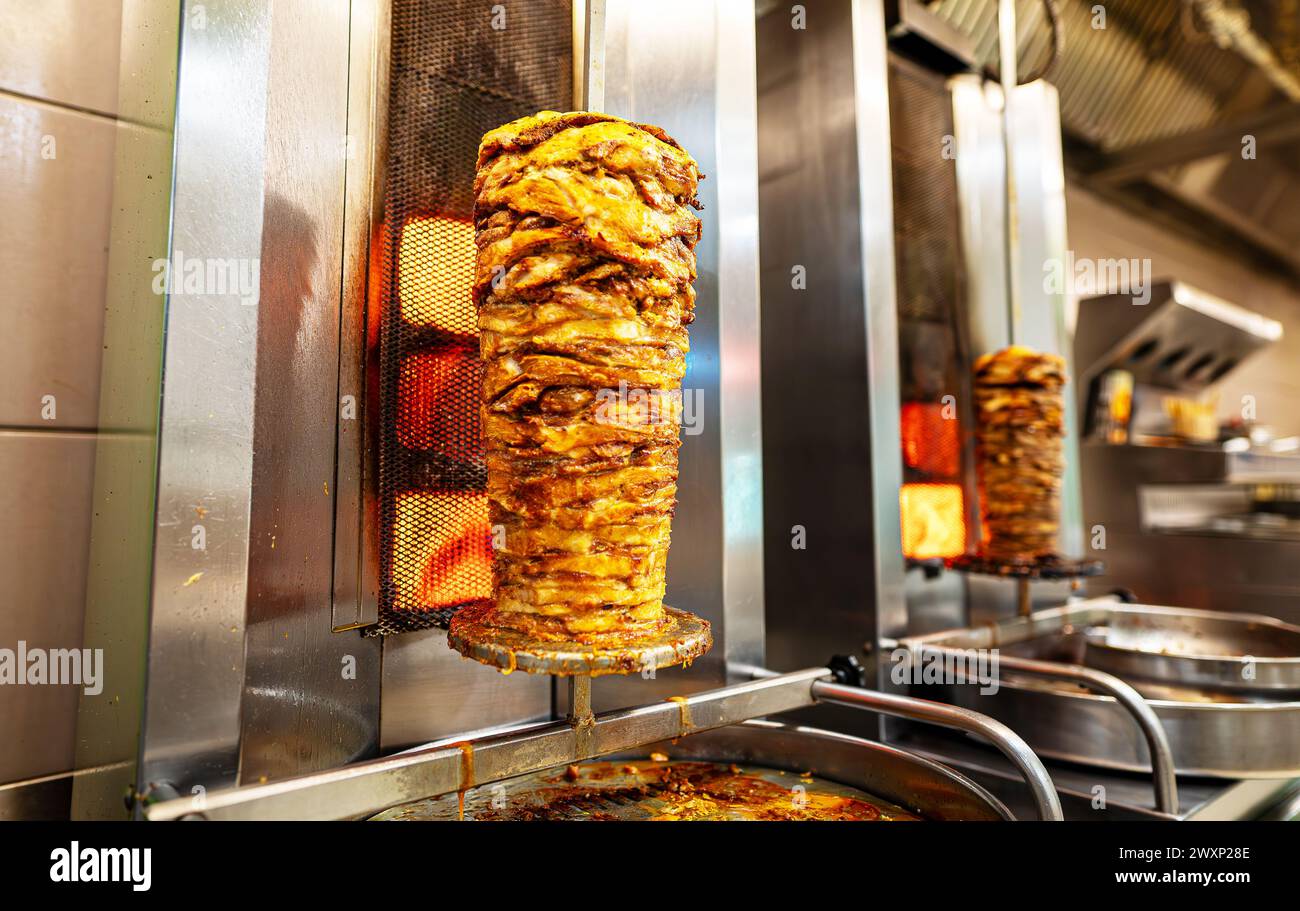 Saftiges Fleisch wird auf einem Shawarma-Spieß gebraten. Stockfoto