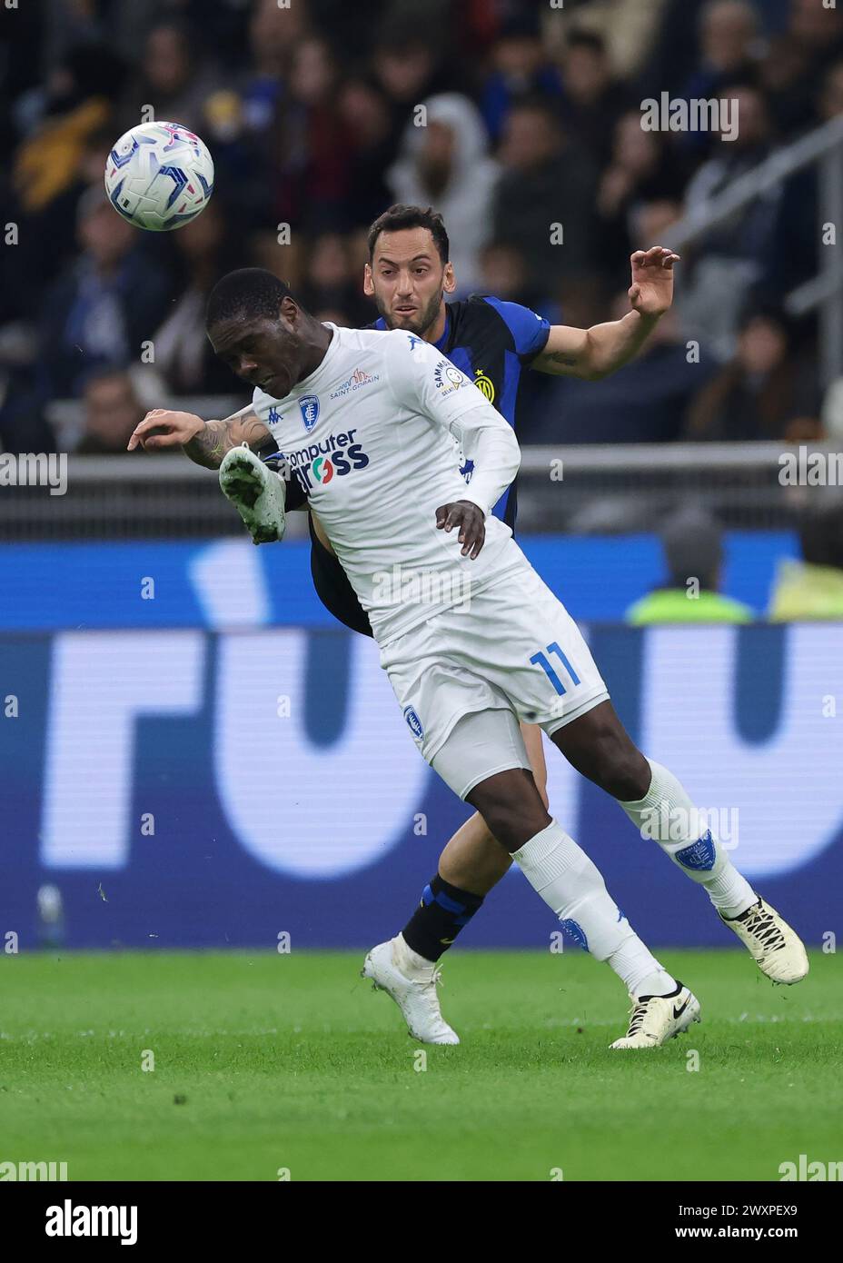 Mailand, Italien. April 2024. Hakan Calhanoglu vom FC Internazionale fordert Emmanuel Gyasi vom Empoli FC heraus, während er den Ball während des Spiels der Serie A in Giuseppe Meazza, Mailand, anführt. Der Bildnachweis sollte lauten: Jonathan Moscrop/Sportimage Credit: Sportimage Ltd/Alamy Live News Stockfoto