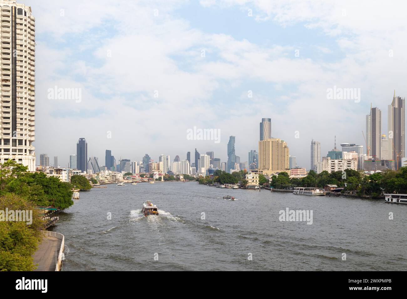 Städtisches Stadtbild mit Wolkenkratzern und Booten am Tag auf dem Chao Phraya Fluss in Bangkok, Thailand. Kopierbereich. Stockfoto